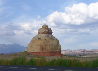 [Lone, large rock formation by roadside.]